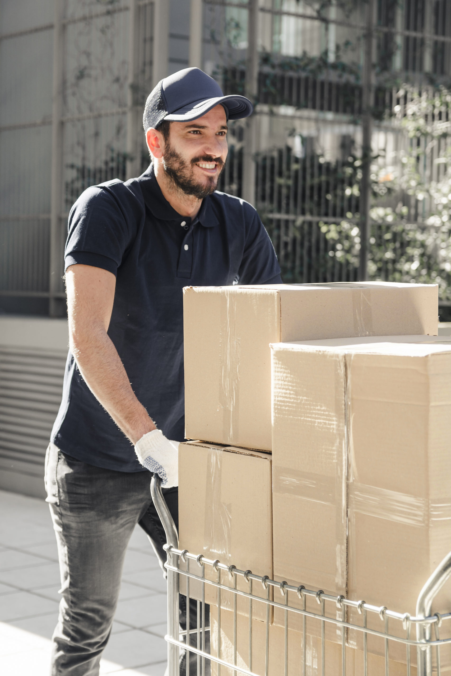 happy-delivery-man-with-cardboard-boxes-walking-sidewalk